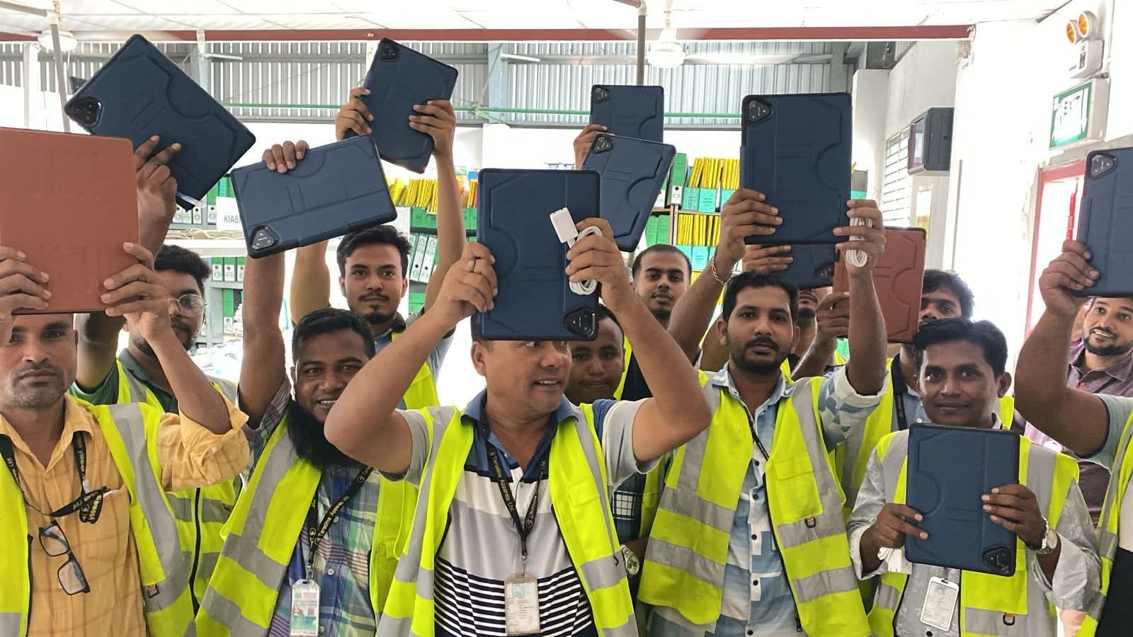 Factory floor team holding tablets running the AegisAI suite